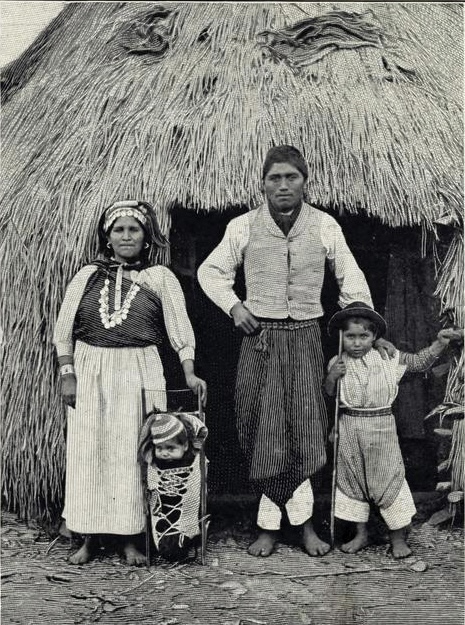 Famille mapuche devant une habitation traditionnelle